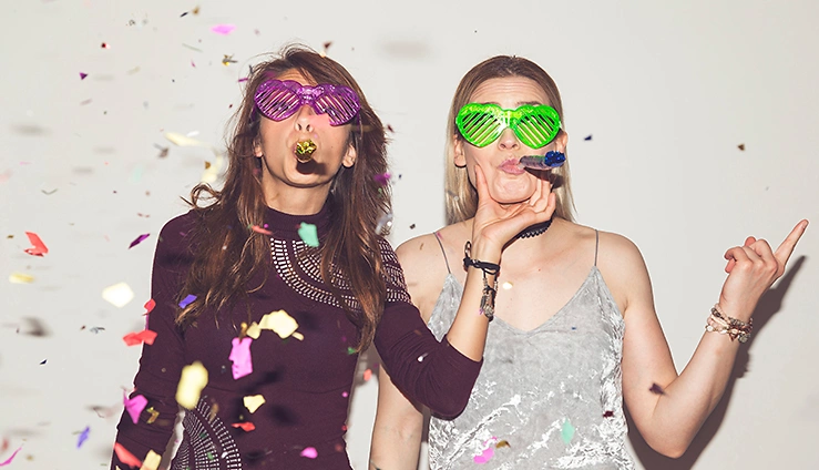 Zwei junge Frauen freuen sich über eine erfolgreiche Partyveranstaltung